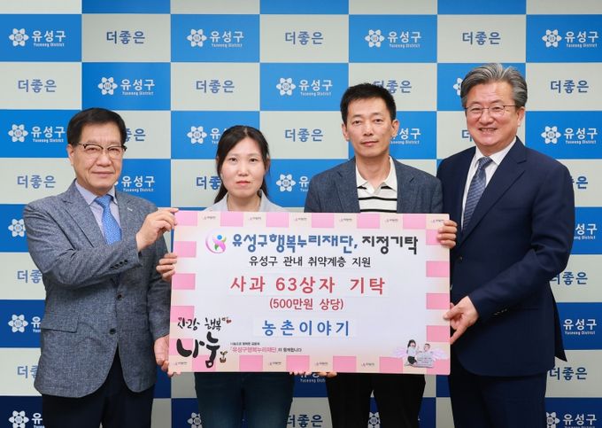 25일 권수경(왼쪽에서 두 번째), 김준섭(오른쪽에서 두번째) 공동대표가 취약계층을 위한 사과를 기탁하고 정용래 유성구청장(오른쪽)과 기념촬영을 하고 있다.