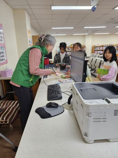 전남선배교직원교육지원봉사센터 자원봉사자가 학교도서관에서 자원봉사를 하고 있는 모습